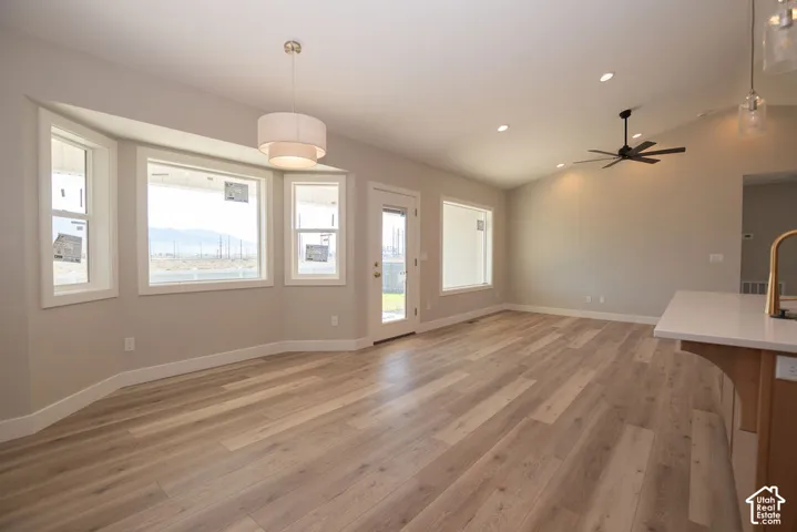 Spacious room with wood-finish flooring, recessed lighting, and a vaulted ceiling