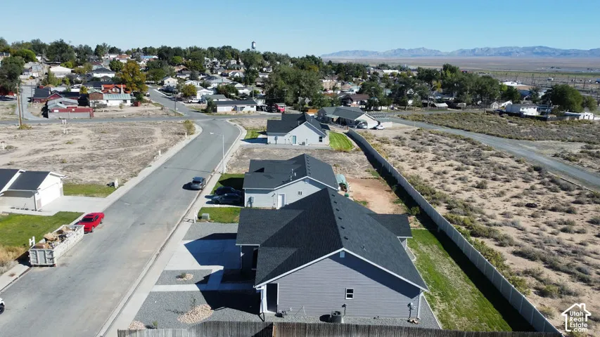 Newly constructed residence featuring gray siding and a dark shingle roof