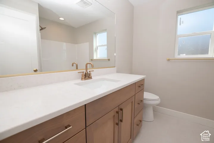 Wood-finish vanity with ample storage, integrated sink, and white countertop