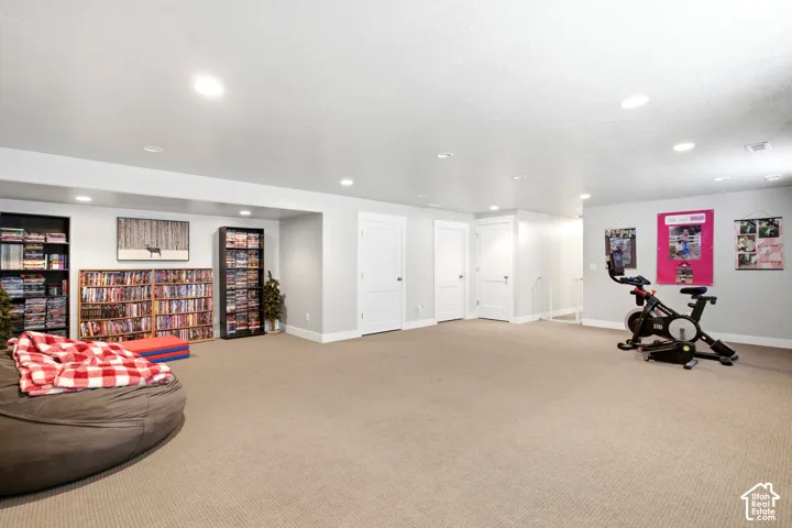 Expansive carpeted room featuring recessed lighting, light gray walls, white baseboards, and multiple white paneled doors