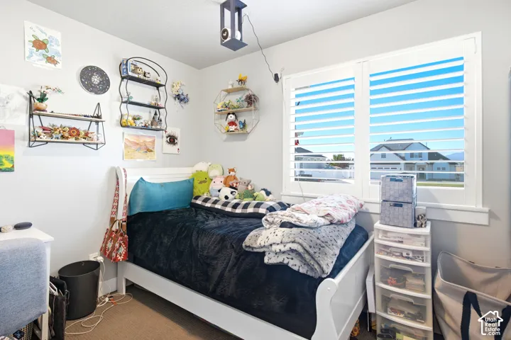 Light-filled bedroom featuring white plantation shutters and neutral wall tones