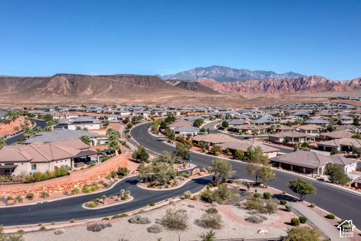 Residential neighborhood with winding paved streets and desert landscaping, set against a backdrop of distant mountains