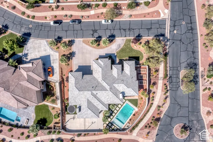 Expansive property featuring a multi-gabled roofline, a private swimming pool, a concrete basketball court, and manicured landscaping with established trees