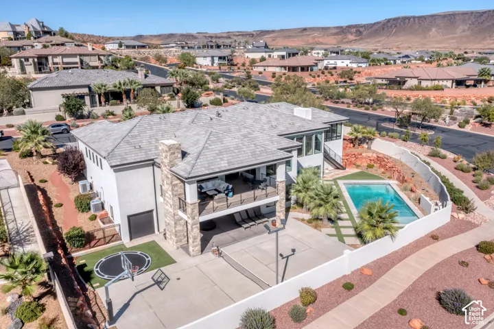 Exterior with a multi-level design, a swimming pool, and a paved sport court