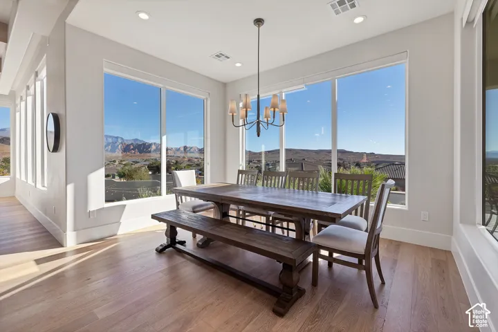 Expansive window array, recessed lighting, wood-finish flooring, and a chandelier fixture