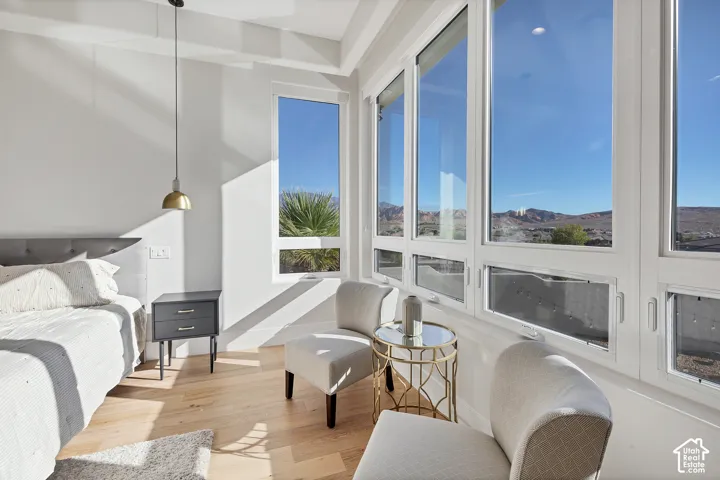 Hardwood flooring, recessed lighting, large windows, tufted headboard, and pendant lighting