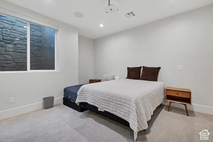 Window with stone-textured exterior, recessed lighting, and light-toned wall finish