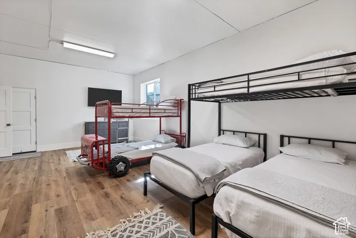 Wood-finish flooring, white walls, and a window providing natural light