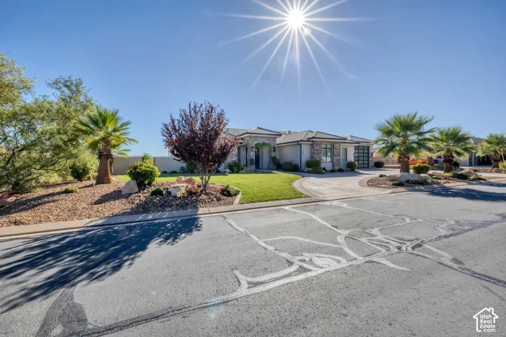 Single-story exterior with a tile roof, a curved concrete driveway, and a front lawn with mature landscaping