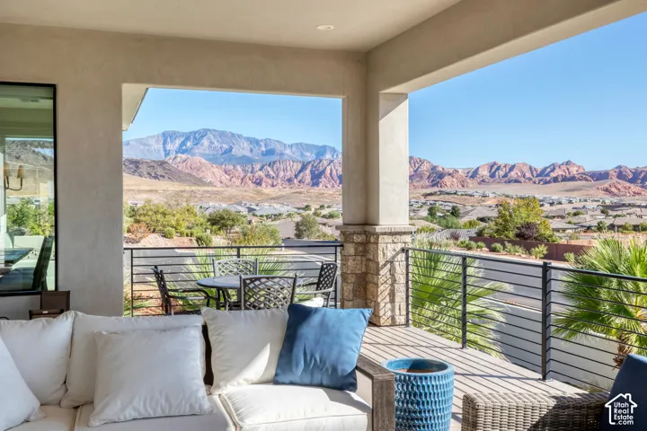 Covered outdoor patio featuring stone column detailing and a horizontal bar railing system