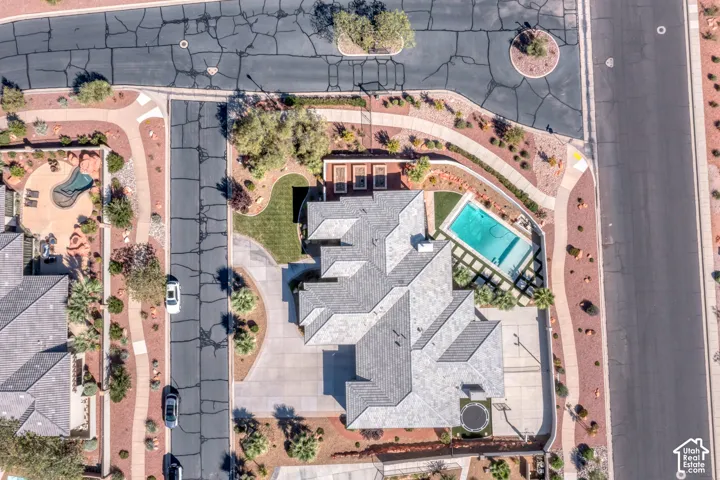 Expansive property featuring a multi-gabled roofline, private swimming pool, paved driveway, and established landscaping