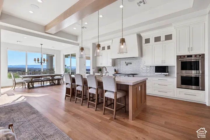 Expansive interior with wood-finish flooring, recessed lighting, and exposed ceiling beams