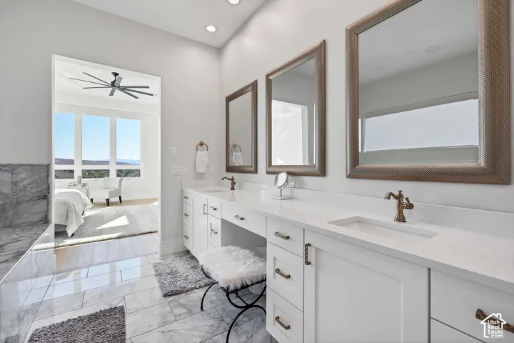 Dual vanity with integrated sinks and white countertops, complemented by white cabinetry and bronze hardware