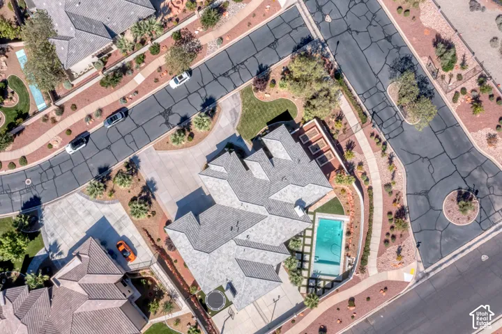 Manicured grounds with a swimming pool, extensive paving, and mature landscaping