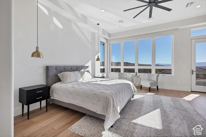 High ceilings with recessed lighting, wood-finish flooring, full-height windows, a modern ceiling fan, and a glass-paneled door