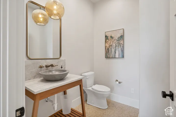 Modern vanity with a gray vessel sink, wall-mounted faucet, and rectangular mirror