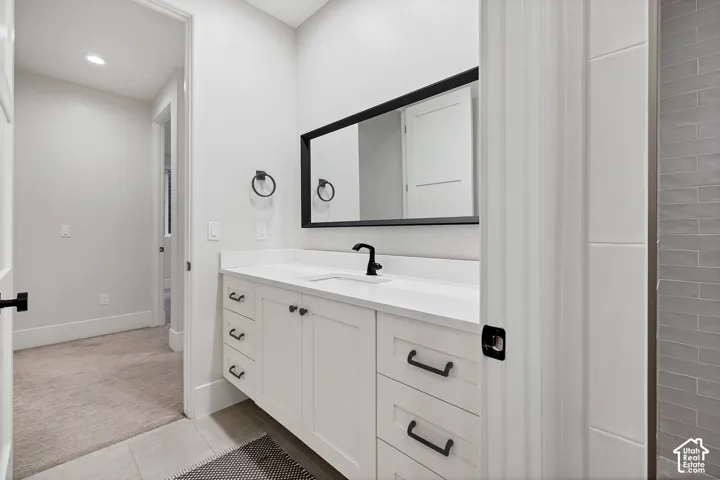 White vanity with integrated sink, black framed mirror, and matte black fixtures