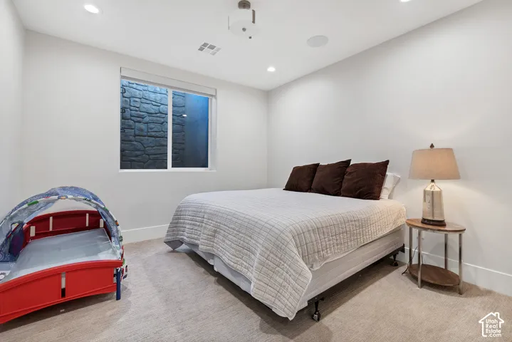 Recessed lighting, wall-mounted projector, in-ceiling speaker, and a window with a stone-clad exterior