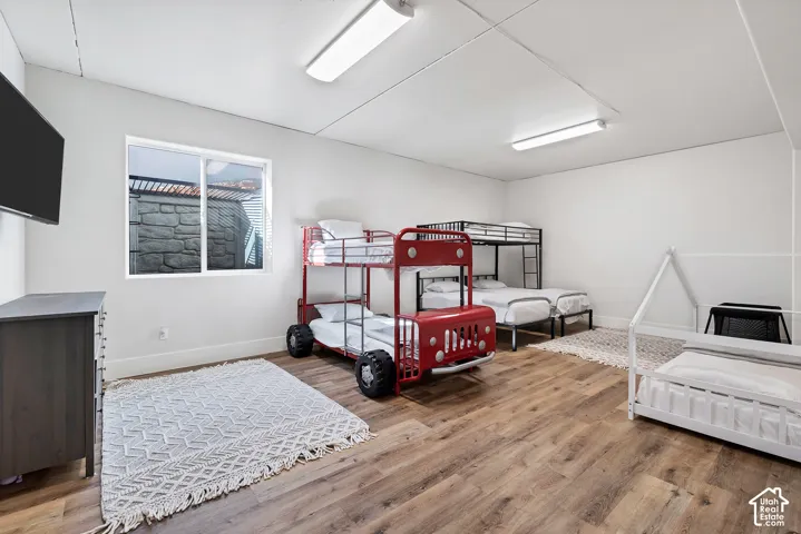 Room featuring wood-finish flooring, white walls, and a recessed window
