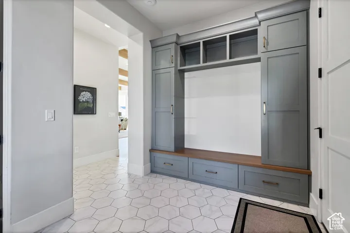 Hexagonal tile flooring, built-in cabinetry, integrated wood-finish bench, integrated cubby storage, and recessed lighting