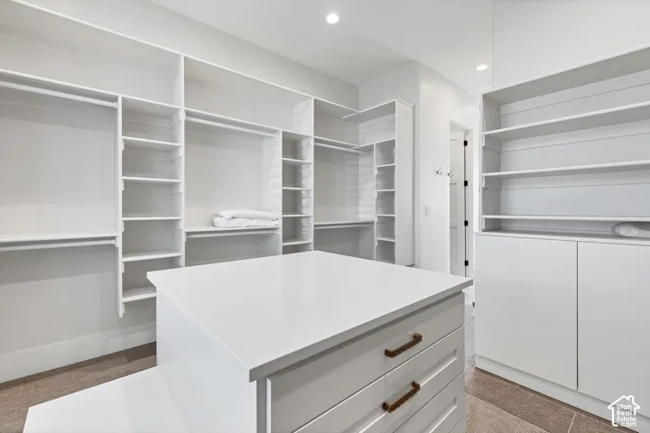 Custom built-in storage system with hanging rods, shelving, and drawer storage