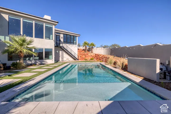 Modern exterior with extensive glazing, private swimming pool, integrated landscaping, and a multi-level patio with exterior stairs