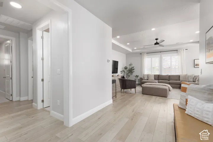 Wood-finish flooring throughout, recessed lighting, and a ceiling fan in the living area