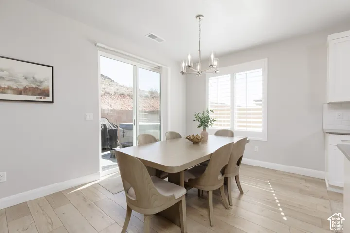 Sliding glass door, wood-finish flooring, recessed lighting, chandelier lighting, window with horizontal blinds