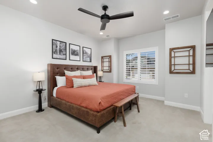 Recessed lighting, ceiling fan, window with plantation shutters, light gray wall paint, and light-toned carpeting