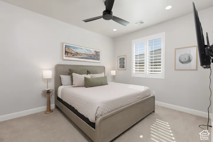 Carpeted room featuring a ceiling fan, recessed lighting, and a window with plantation shutters