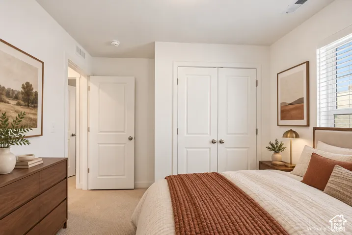Neutral tone wall color, carpet flooring, window with blinds, interior doors with satin nickel hardware, and a closet with bifold doors