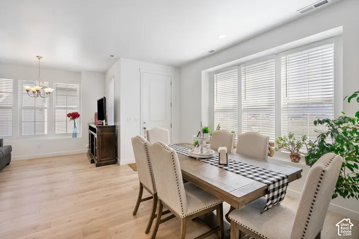 Light wood-finish flooring throughout, bright white walls, multiple large windows with blinds, built-in window sill, and recessed lighting
