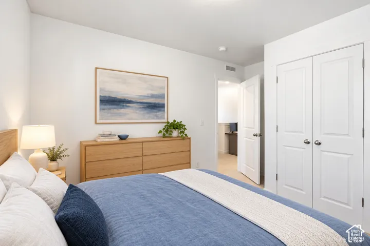White walls, light wood-finish flooring, and white bi-fold closet doors