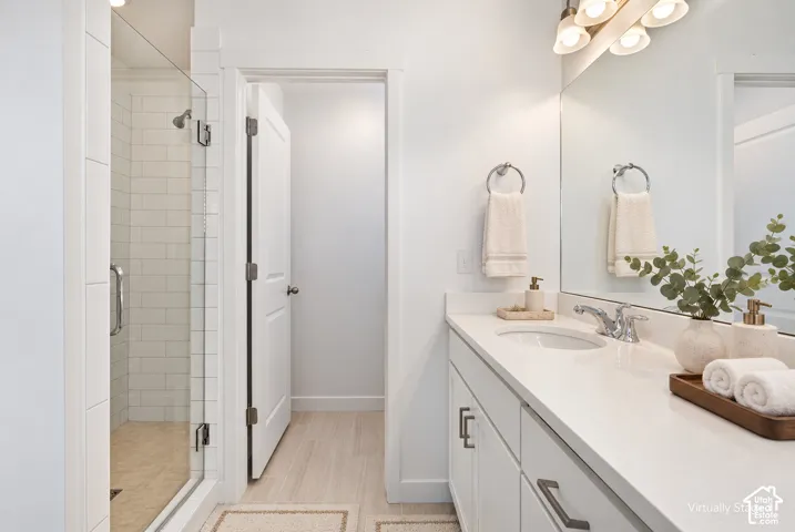 White vanity with integrated sink, chrome faucet, and expansive wall mirror