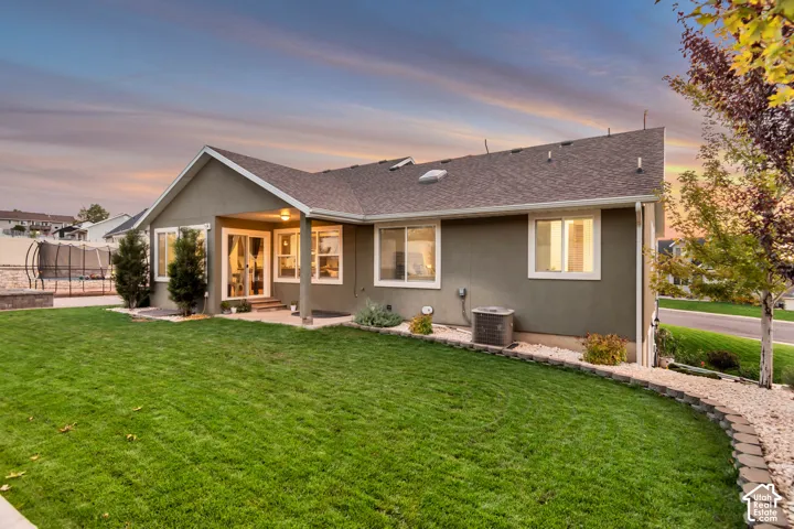 Expansive green lawn with a rock-edged garden bed