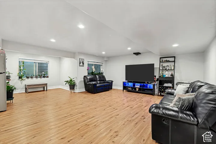 Spacious room featuring wood-finish flooring, recessed lighting, and multiple windows