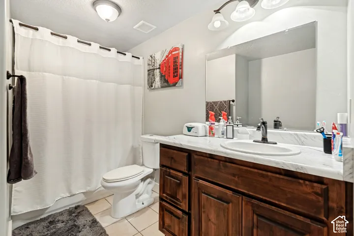 Bathroom featuring a vanity with dark wood-finish cabinetry, a white countertop, and an integrated sink