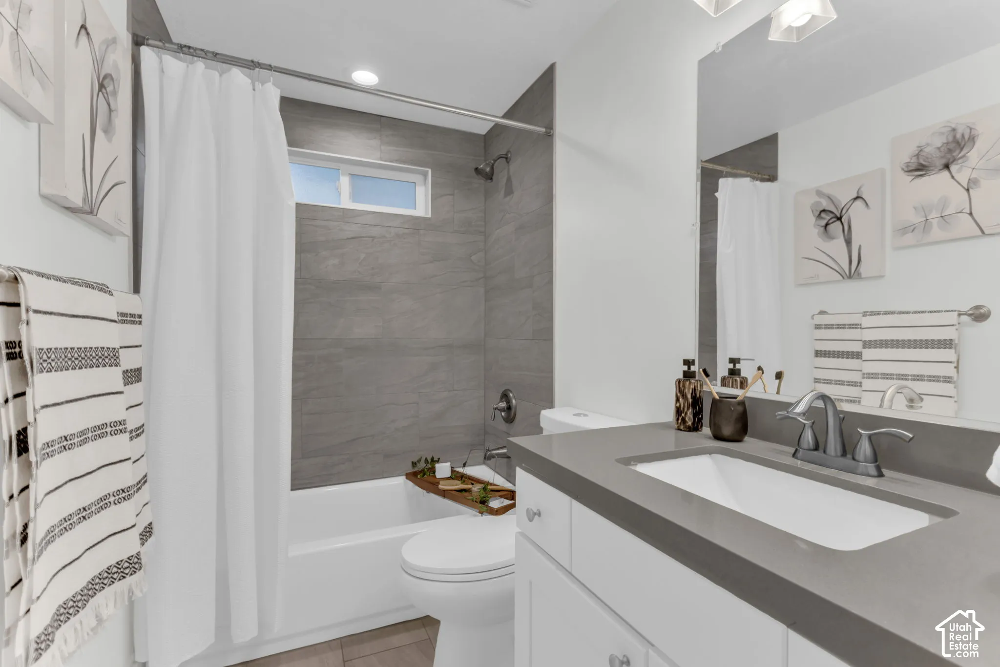 White vanity with a rectangular undermount sink, a gray countertop, and a chrome faucet