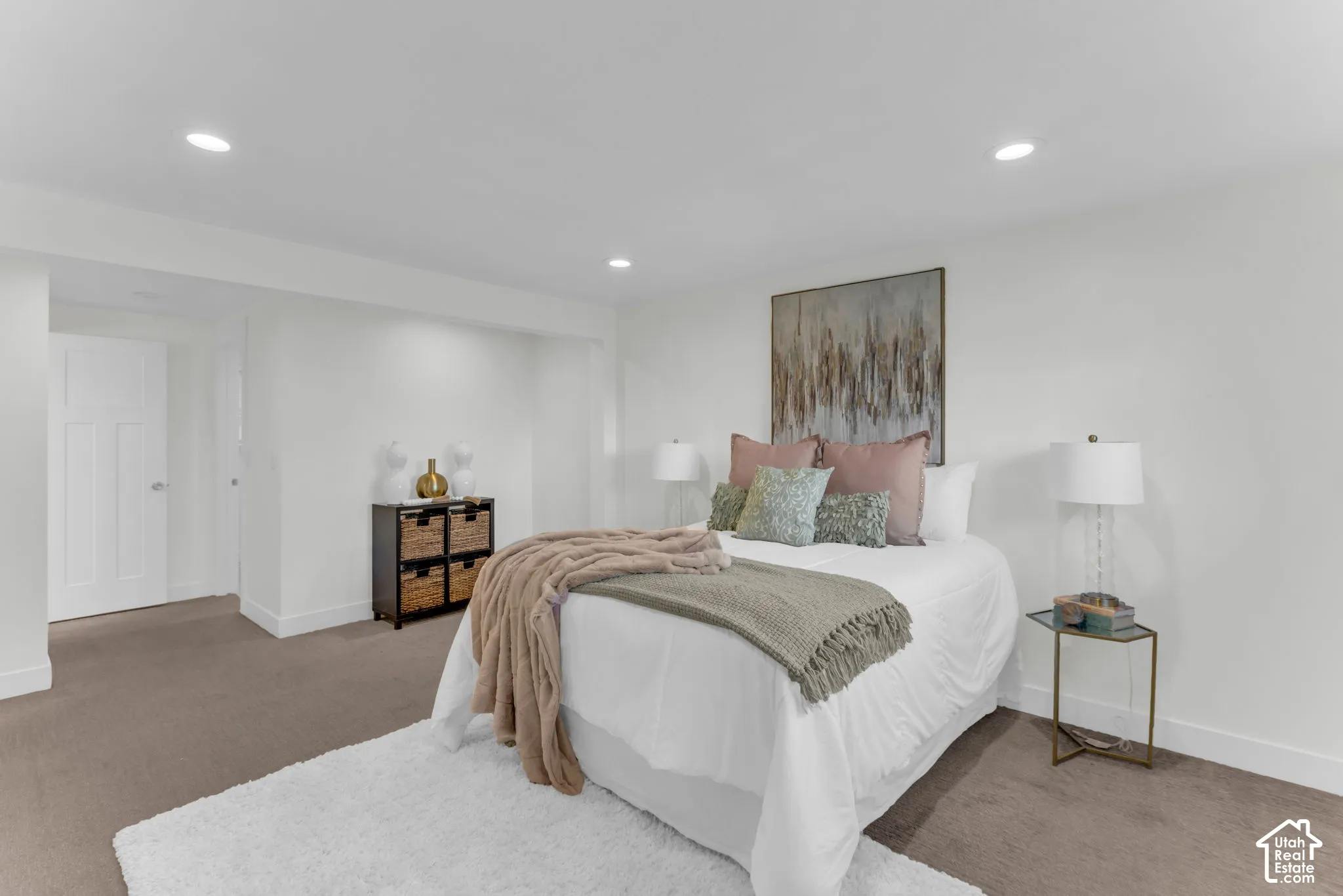 Recessed lighting illuminates the space, featuring white walls and a white paneled door