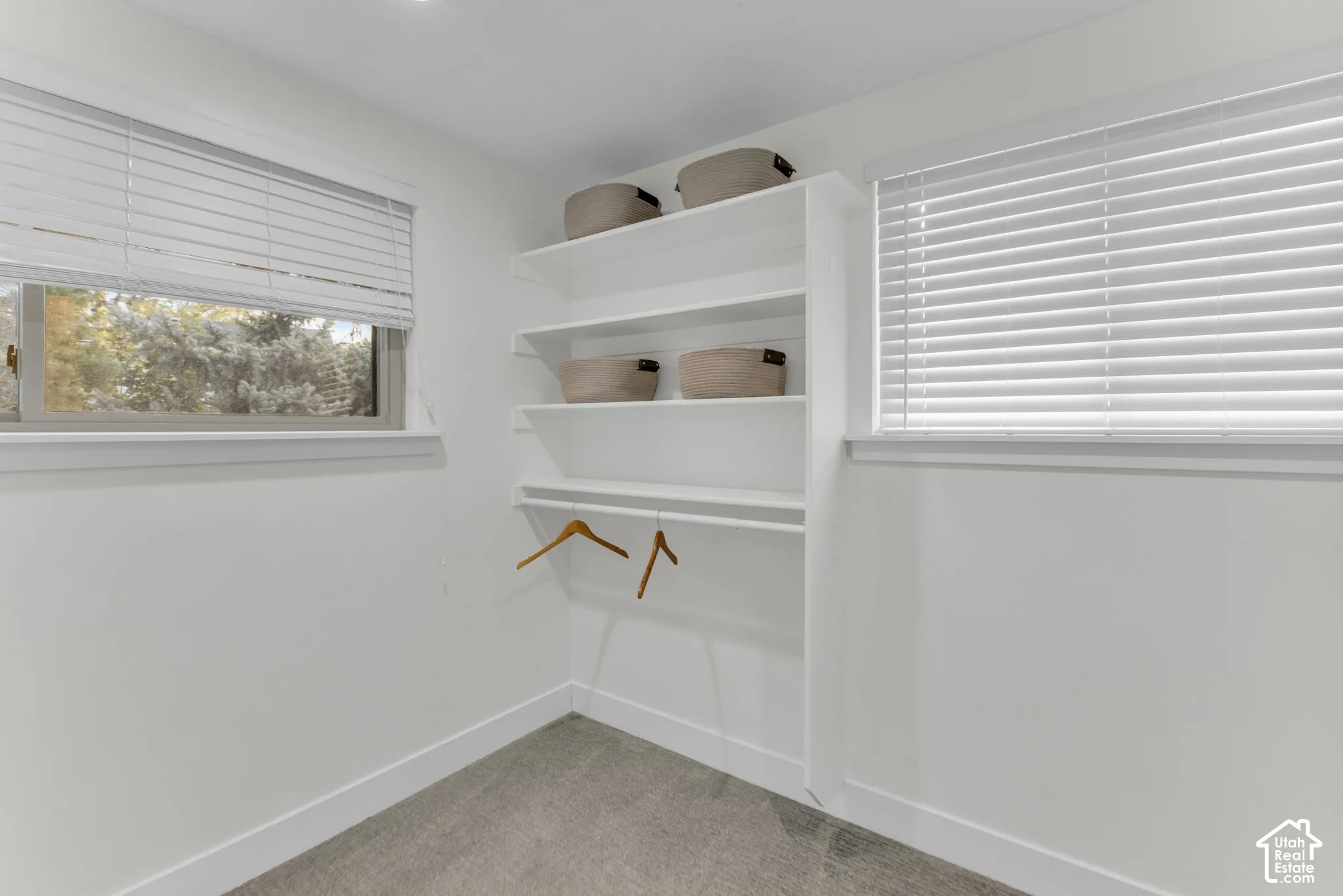 Built-in shelving with hanging rod, dual windows with blinds, and recessed lighting