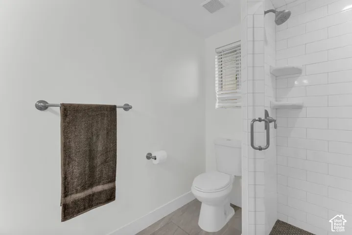 White subway tile shower enclosure with built-in shelving and glass door