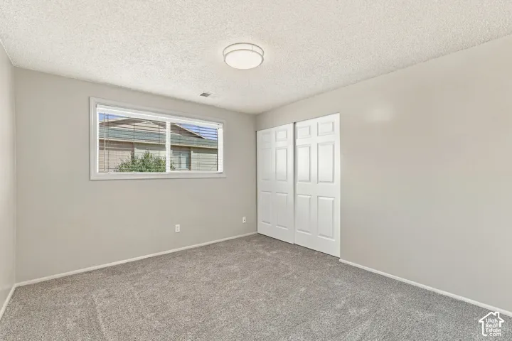 Bedroom #2 with recessed window with blinds, light gray wall paint, and gray carpet flooring