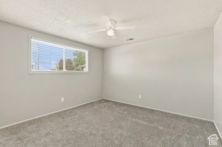 Bedroom #1 with neutral wall finishes with a window featuring horizontal blinds