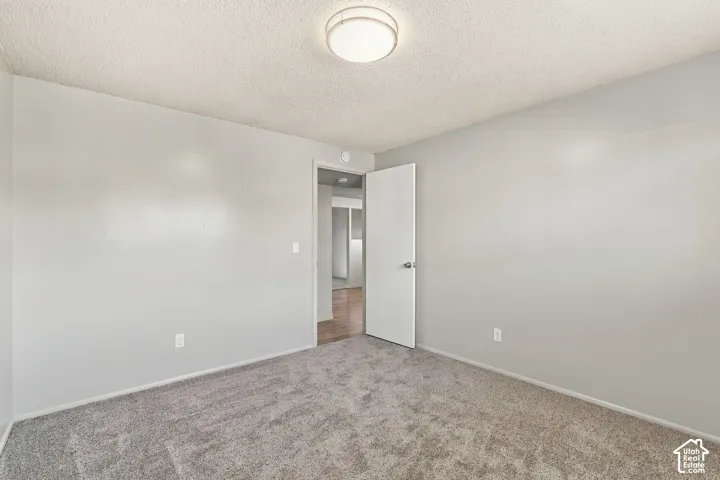 Bedroom #2 with textured ceiling with a flush-mount light fixture