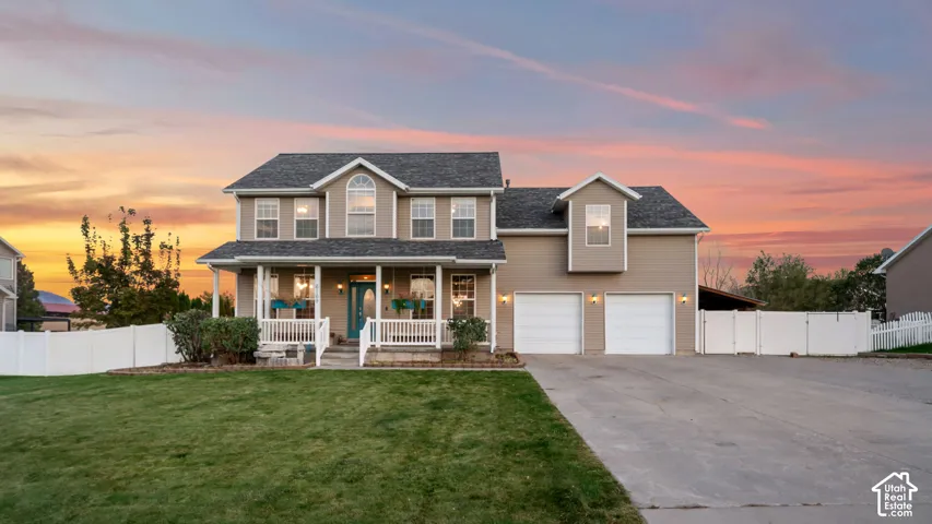 Two-story residence with a covered front porch, white railing, and decorative columns