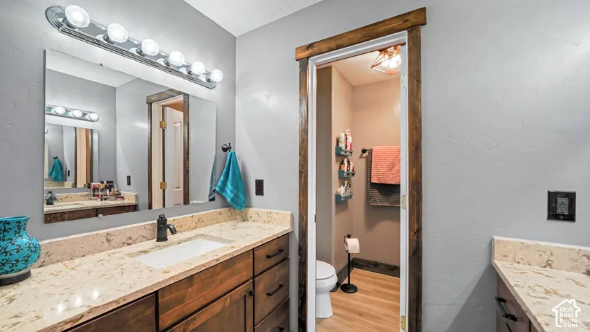 Bathroom featuring a vanity with a light-toned countertop, integrated sink, and wood-finish cabinetry