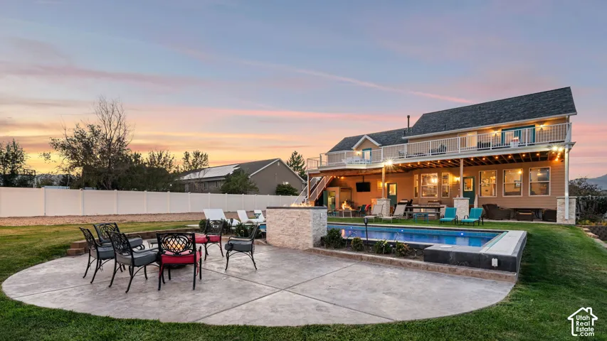 Expansive backyard featuring a built-in swimming pool, a stamped concrete patio, and a stone-clad fire pit