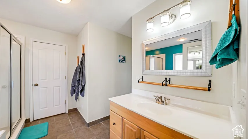 Vanity with integrated sink, wood-finish cabinetry, and brushed nickel faucet