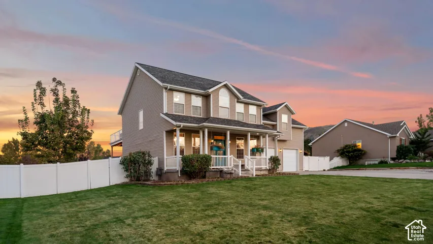 Two-story residence with a covered front porch, white railing, and an attached two-car garage