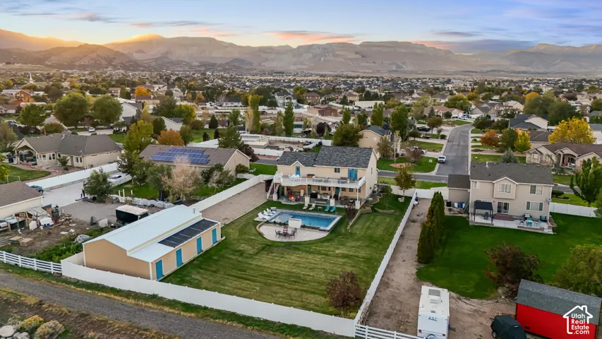 Expansive property featuring a two-story residence, detached outbuilding with solar panels, private swimming pool, and a white picket fence